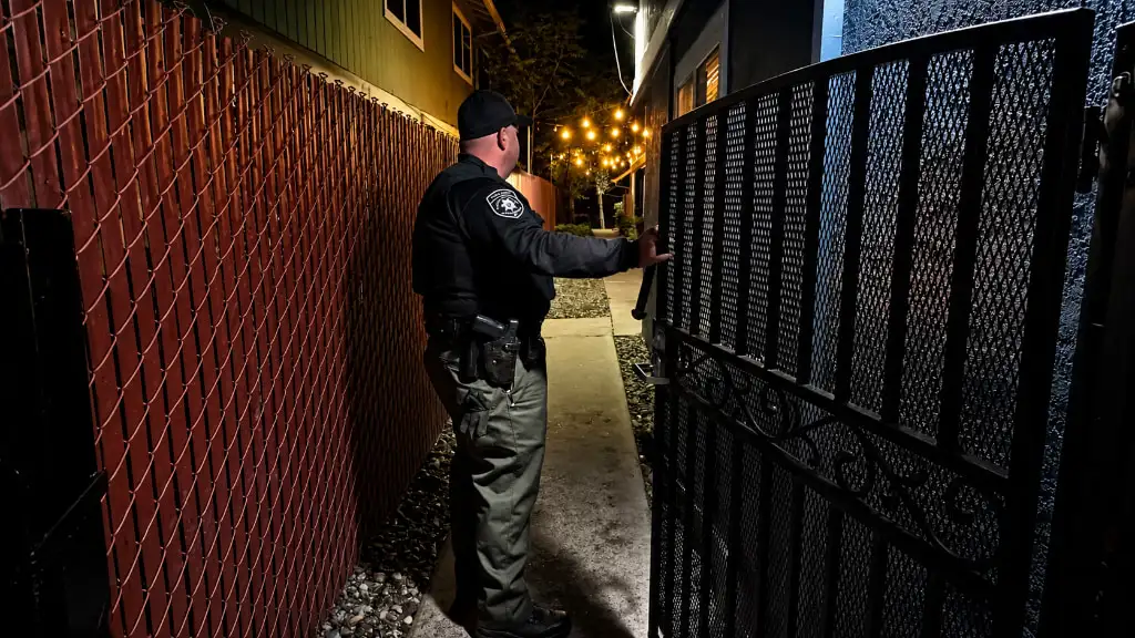 GPI patrol officer checking a gate at night at a Sacramento property